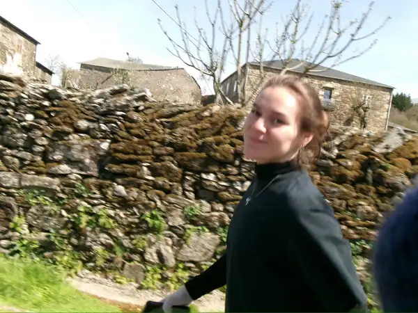 Agus caminando junto a las casas de piedra