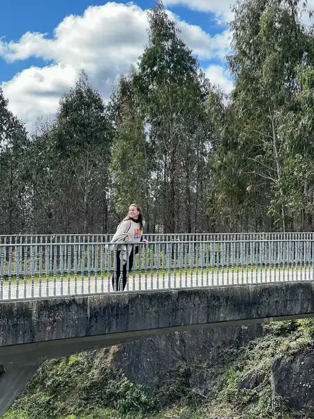 Agus sobre un puente rodeado de árboles